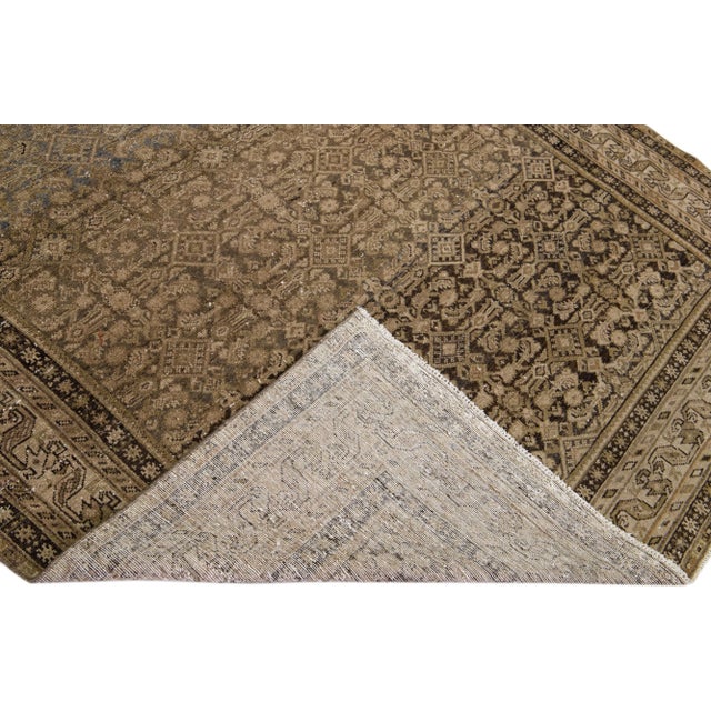 Beautiful antique Malayer hand-knotted wool rug with a tan color field. This Malayer piece has a designed frame with brown...