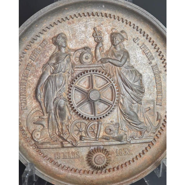 I’m selling a mid-1800's cast iron allegorical plaque shaped like a cog or moulded gear, dated March 19th 1853 and made by...