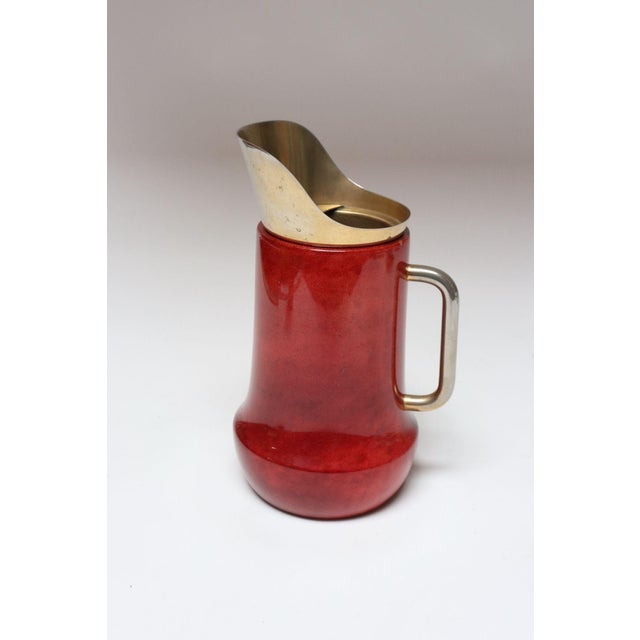 Aldo Tura Italian walnut pitcher wrapped in lacquered dyed-red goatskin with brass spout and handle (ca. 1950s, Italy)....