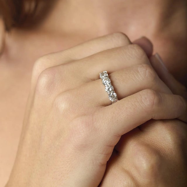 This dazzling vintage platinum ring showcases fifteen luminous round brilliant diamonds, radiating exceptional fire and...