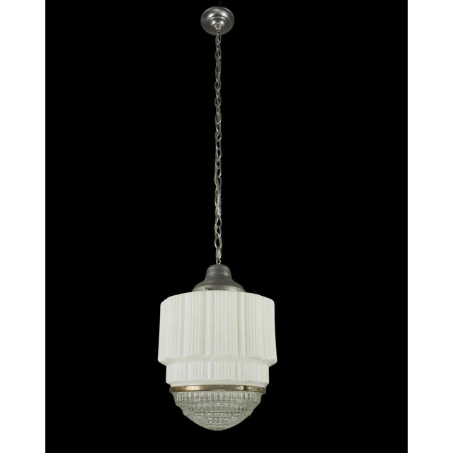 Art Deco style pendant light featuring a white milk glass globe with a clear Fresnel glass lens and a brushed steel chain...
