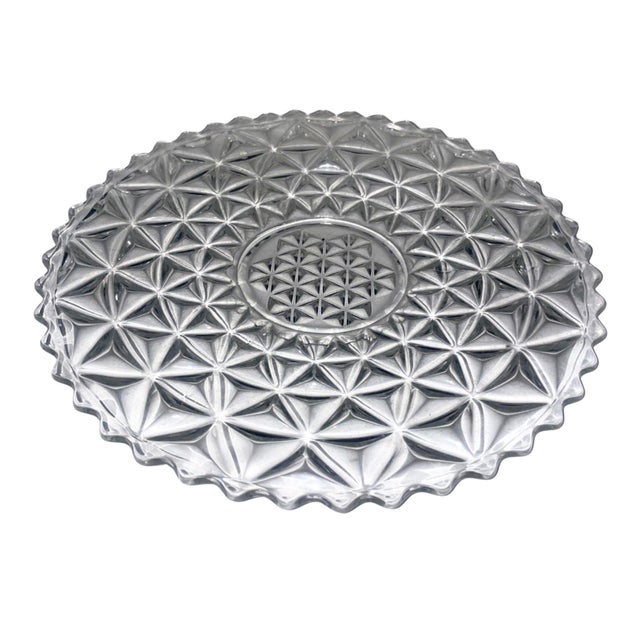 This vintage Tiffin-Franciscan Williamsburg cake plate is made of pressed clear glass with a star pattern. It has a...