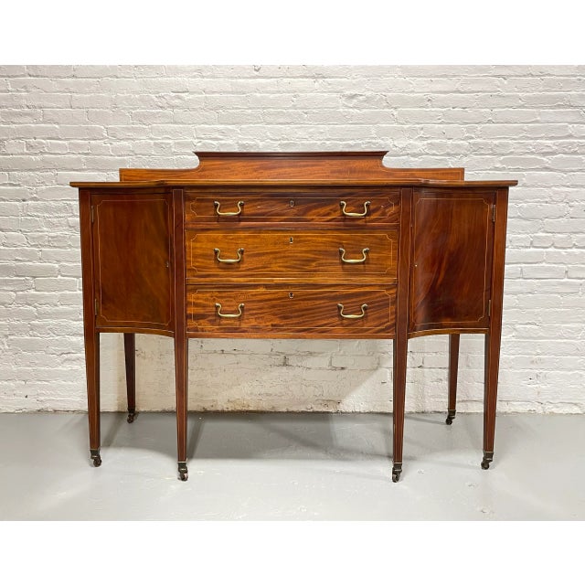 Exquisite Mahogany Sheraton style Sideboard, c. 1910. Stunning flame mahogany wood grains. This cabinet is raised on 6...