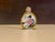 Elegant Famille Rose porcelain snuff bottle featuring finely hand‑painted floral and figural motifs in soft rose, emerald,...