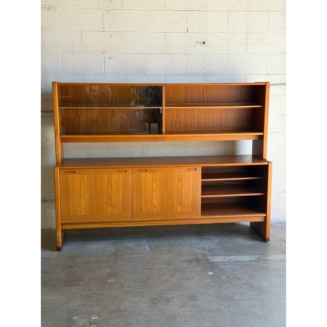 This impressive two-piece hutch features sliding lower doors and an upper display section with shelves and built-in...