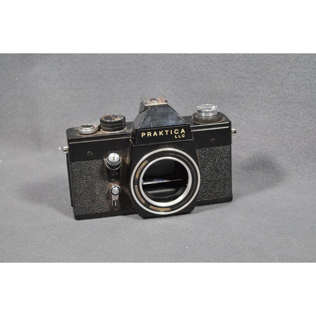 A very nice vintage East German 35mm camera set, centered around a Praktica LLC SLR camera body and accompanied by a...
