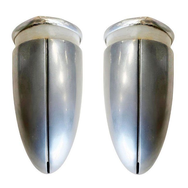 One brushed aluminum Streamline Art Deco wall sconce featuring a round body with a lucite cutout for accent lighting along...