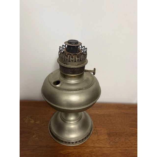 Antique Rayo center-draft kerosene oil lamp with nickel-plated metal body and ornate burner. Missing the fuel tank cap....