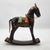 This vintage rocking horse showcases artisanal craftsmanship with a wooden base, intricate brass detailing, and inlaid...