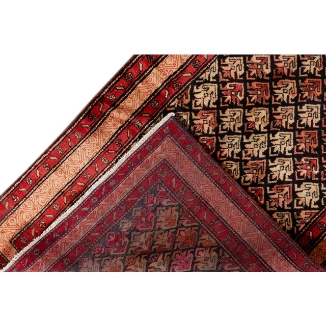 Beautiful vintage North West Persian hand-knotted wool rug with a red field. This piece has peach, black, and orange...