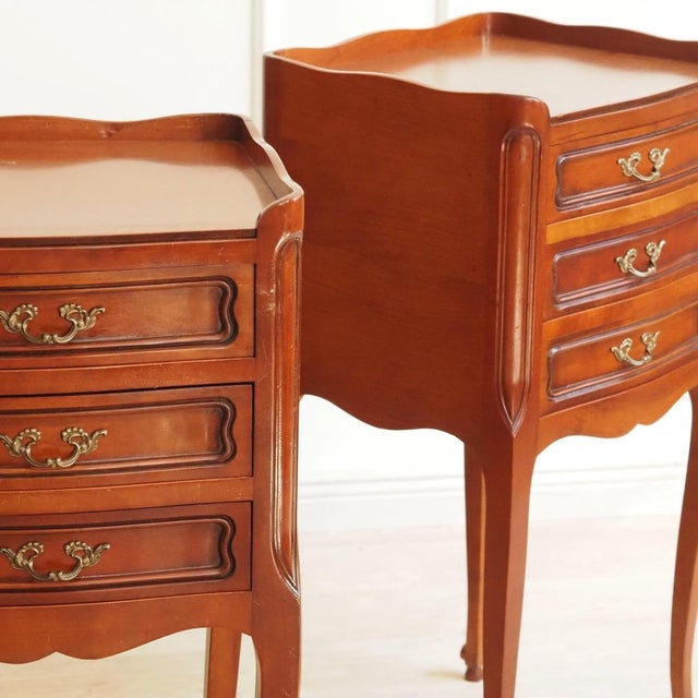 A pair of louis xv-style bedside tables (chevets), crafted in the 20th century based on historical models. The curved...