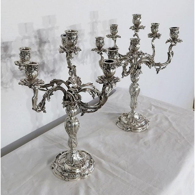 Set of two silvered bronze candlesticks, each lighting with a torch arm in the middle and five off-centers. We can...