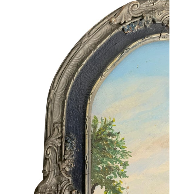A charming vintage folk art landscape painting on board depicting a tranquil lake nestled among rolling mountains, lush...