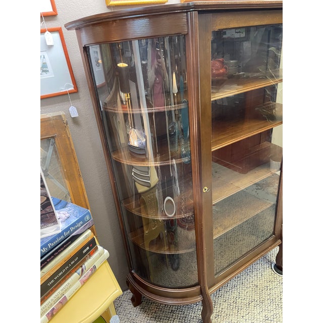 Antique curved glass or bow front oak curio cabinet with interior shelves for display. Praben