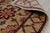 A 3' x 10' hand-knotted wool runner with a beige and gold field with a rust and brown floral lattice, in a low, dense...
