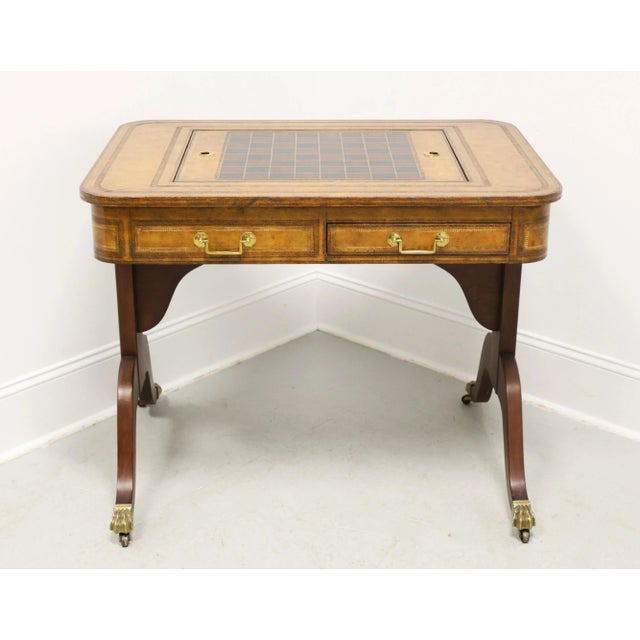 A Regency style game table by Drexel Heritage. Mahogany with a lighter finish, a banded embossed & tooled leather top,...