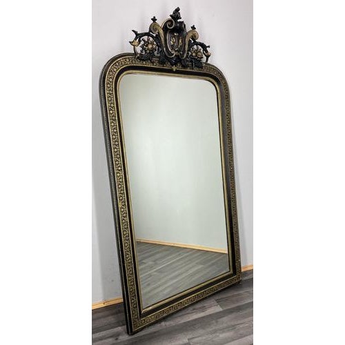 This elegant Vintage French mirror showcases a richly decorative frame with elaborate scrolling and classical...
