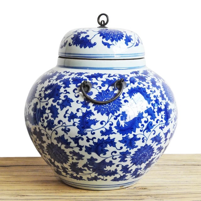 Traditional blue and white hand painted ceramic urn with lid. Features black iron ring handles. Wonderful display piece...