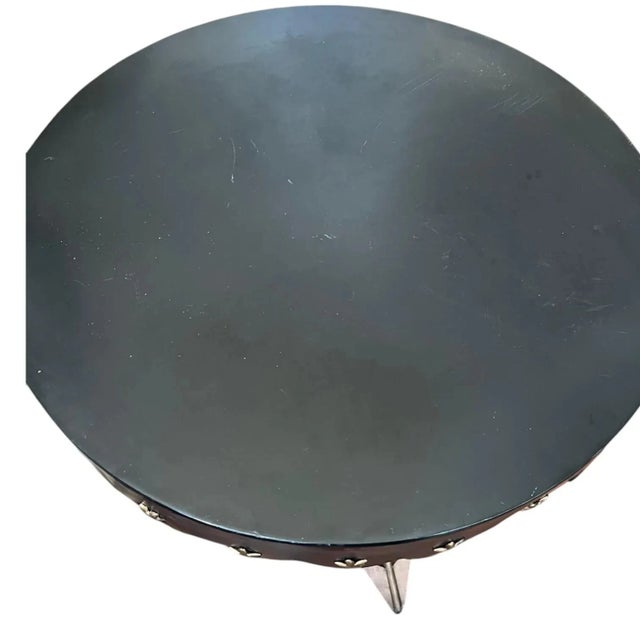 Handcrafted antique Neoclassical crossed arrow side table. The all metal black top has a napkin cut rim decorated with...
