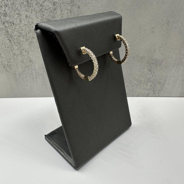 These natural diamond hoop earrings in 14kt yellow gold feature 0.70 carats total weight of HI SI round diamonds, offering...