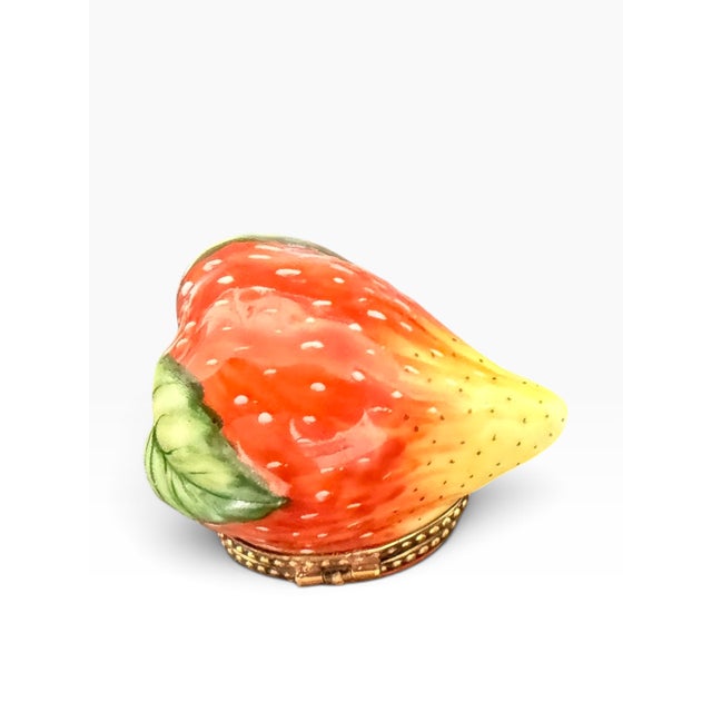 Add a touch of French charm to your collection with this delightful hand-painted Limoges porcelain strawberry trinket box...