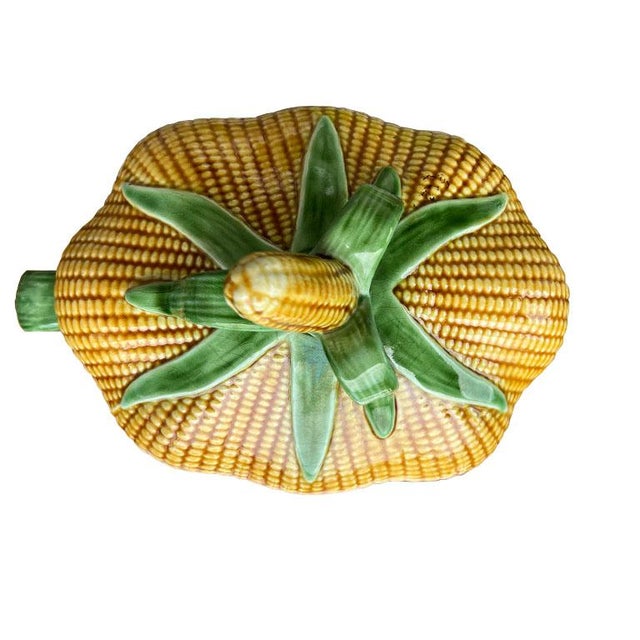A unique large corn husk motif tureen in yellow and green. This dish is oval and created from ceramic. Both the lid and...