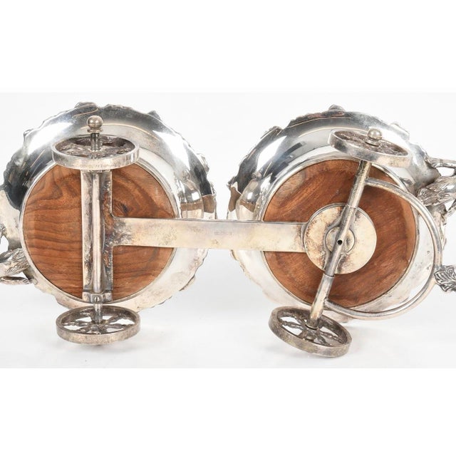 A striking vintage silver plate double wine trolley or wine carriage, designed to hold and serve two bottles of wine or...