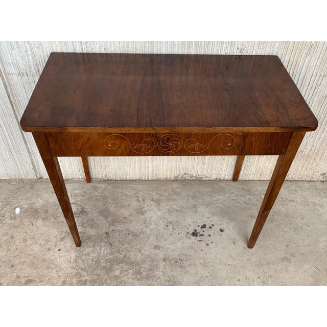 Early 20th century console in wood veneer. It features beautiful marquetry of rinceaux and floral motifs in drawer. It is...