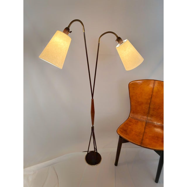 This Danish two-arm floor lamp is attributed to Svend Aage Holm Sørensen and dates to the late 1950s, a period defined by...
