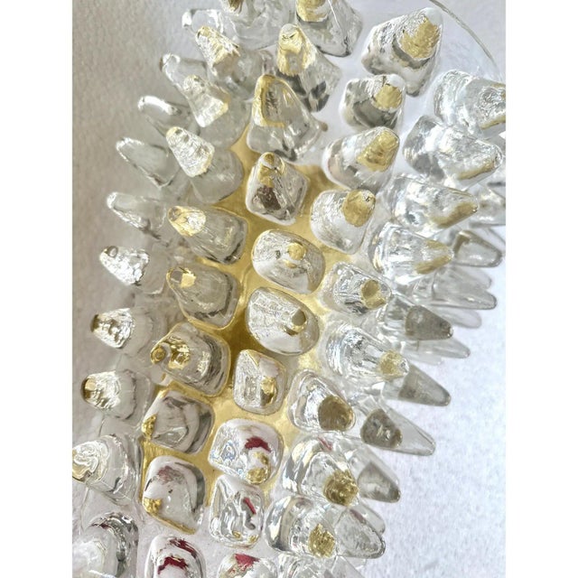Elegant pair of Italian wall sconces crafted in clear Murano glass with "spikes" that light-reflecting and made...