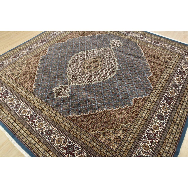 A traditional Tabriz Mahi rug hand-knotted with an all-wool pile on a cotton foundation. This finely woven oriental rug...