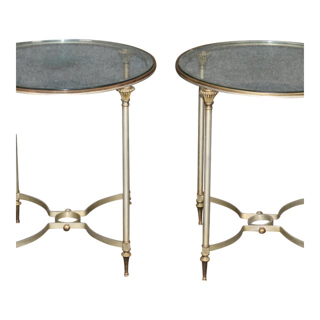 This is a fantastic and rare pair of steel and brass Directoire style end tables or gueridons attributed to Maison Jansen....