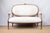 An antique settee, c. 1890, French. Louis XVI style, featuring original carved wood frame with floral motifs and...