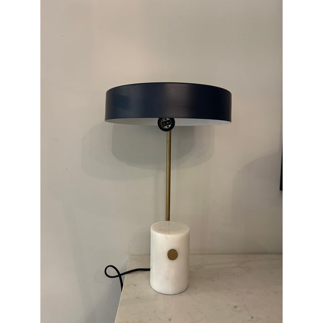 Renwil mid century table lamp with white marble base, antique brass neck and blue metal shade. A few small dings on the...