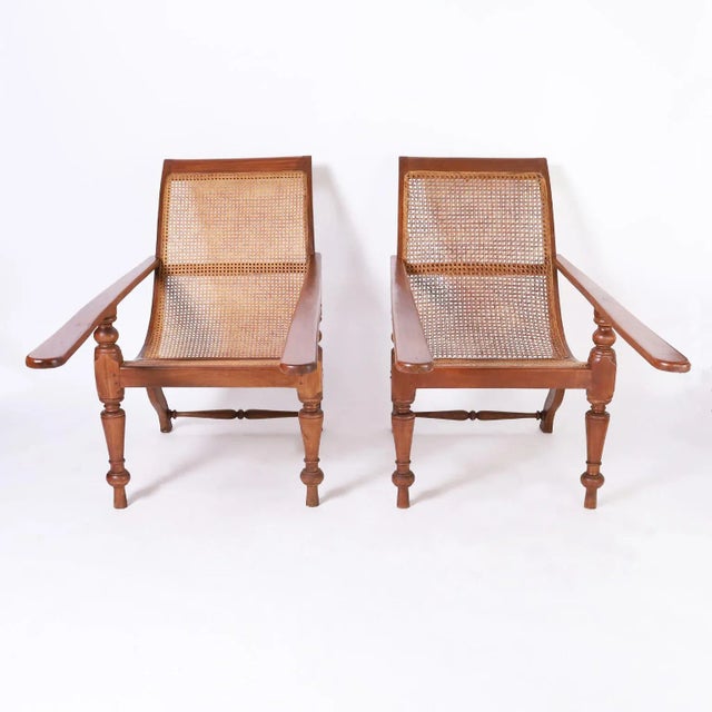Intriguing pair of early 20th century British Colonial plantation chairs handcrafted in indigenous mahogany with elegant...