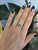 A natural tsavorite garnet from Tanzania glows vivid green at the center of this ring, framed by earth-mined diamonds in...