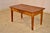 19th century cherry coffee table from France. The top is made from planks and follows down to a simple apron, containing a...