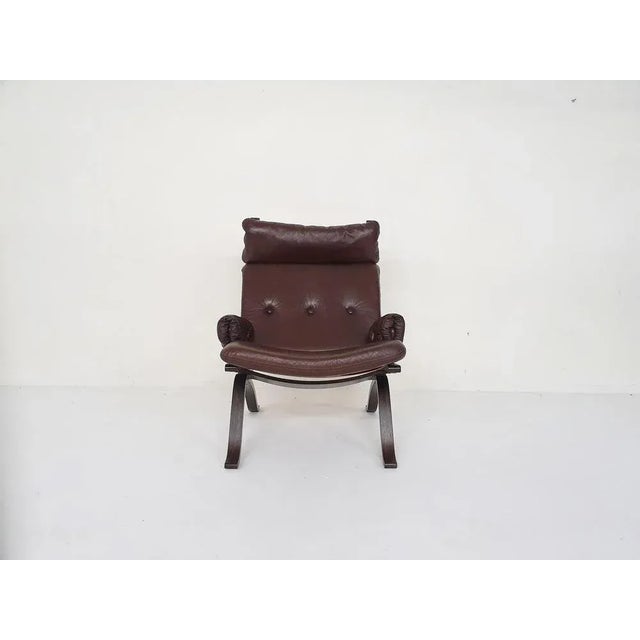 Brown lounge chair with brown faux-leather cushions and canvas back. Attributed to Ingmar Relling for Westnofa and in the...