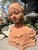 A charming French-style terracotta bust depicting an elegant young woman in romantic Art Nouveau-inspired dress. The...