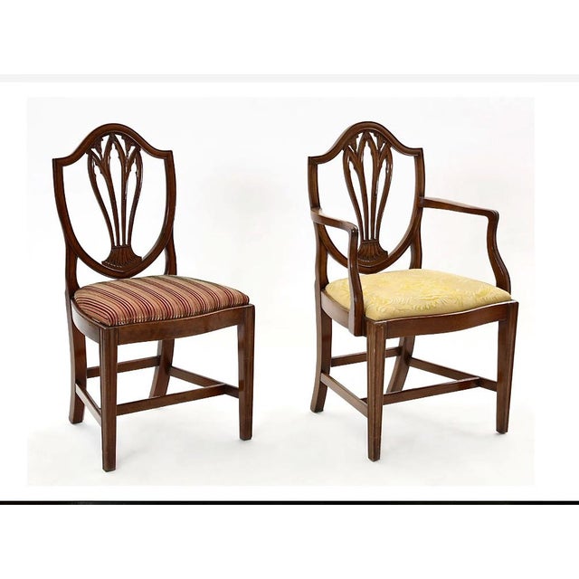This is a superb set of assembled George III Dining Chairs after a model by George Hepplewhite. The two arm chairs and...