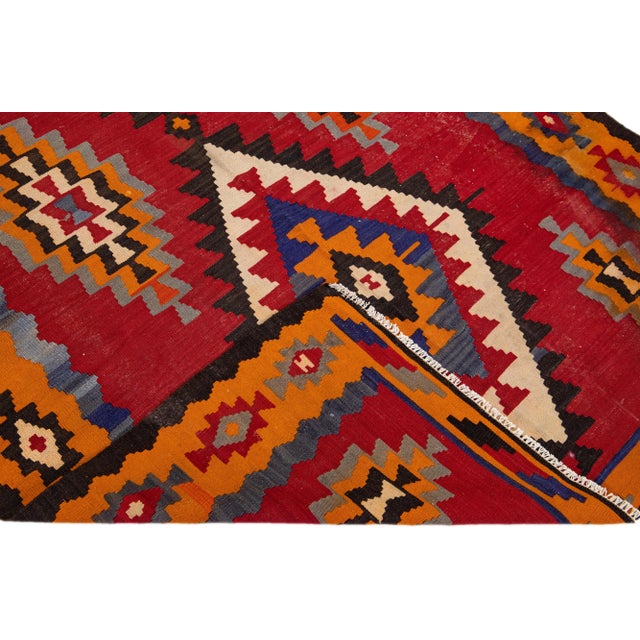 Beautiful vintage Turkish Kilim hand-knotted wool rug with a red field. This piece has an orange frame and multicolor...
