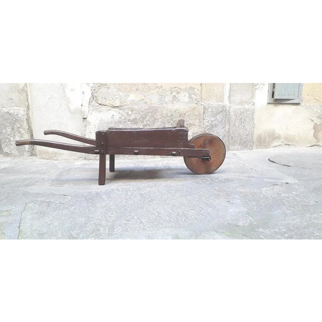 Antique wooden cart from the 1800s with wrought iron parts and wooden wheel covered in iron. Restored item, ideal for...