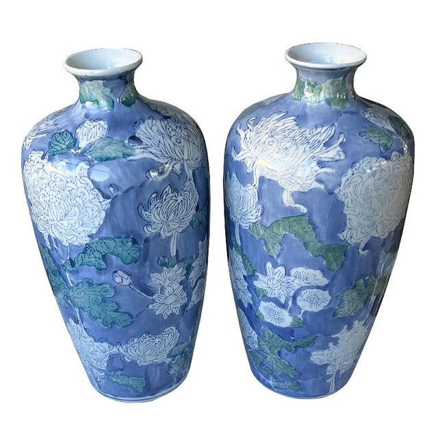 A pair of timeless ceramic vintage blue and white floral vases. This set comes as a pair and will elevate any space. A...