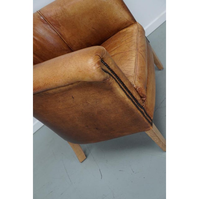 This cognac-colored leather club chair comes from the Netherlands. It is upholstered with cognac-colored leather and...