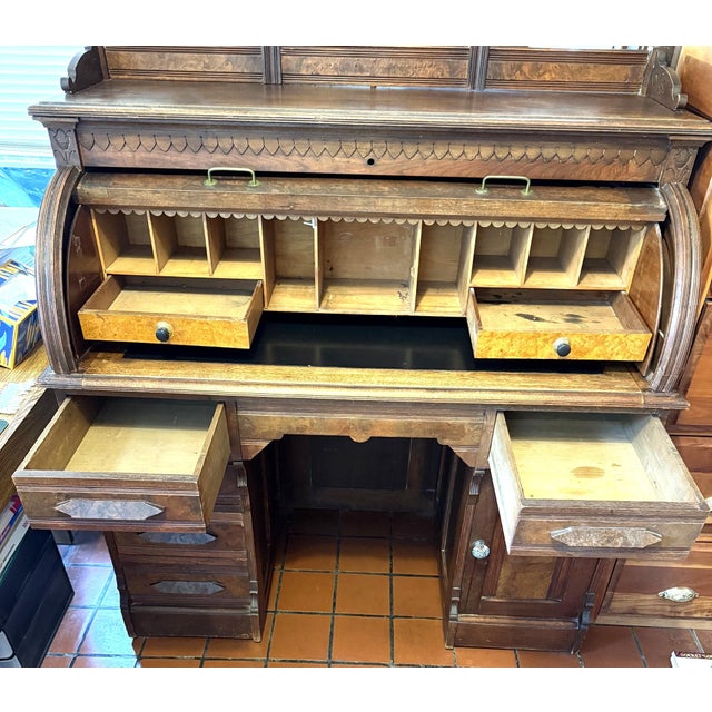 This is a spectacular, walnut roll top desk which is very functional with its five drawers on the lower half, two Birdseye...