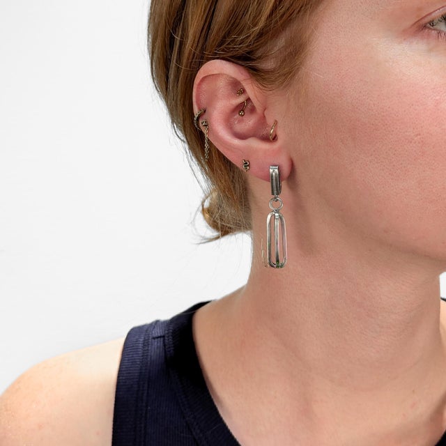 A pair of fine Mid-Century Modern silver drop or dangle earrings. In sterling silver. By Paul Lobel. Each with an openwork...