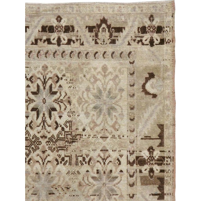 This mid-20th-century Turkish Anatolian small gallery carpet presents a densely patterned field of repeating floral and...