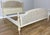 An elegant Vintage French king size bed featuring a soft painted finish, beautifully shaped cane panels to the headboard...