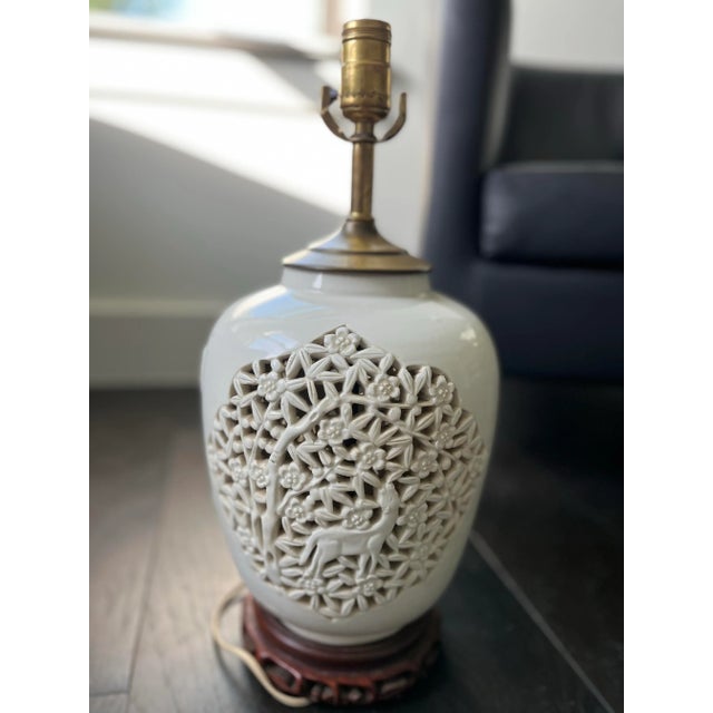 A gorgeous ginger jar lamp with a unique depiction of a deer in a bed of cherry blossoms. On one side the deer is eating...