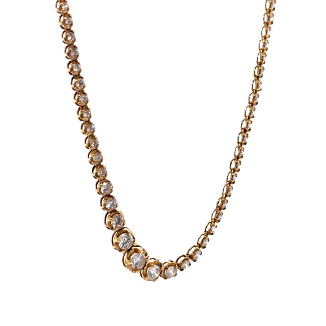 This elegant 18ct yellow gold diamond tennis necklace is finely crafted in a classic graduated design, showcasing a total...